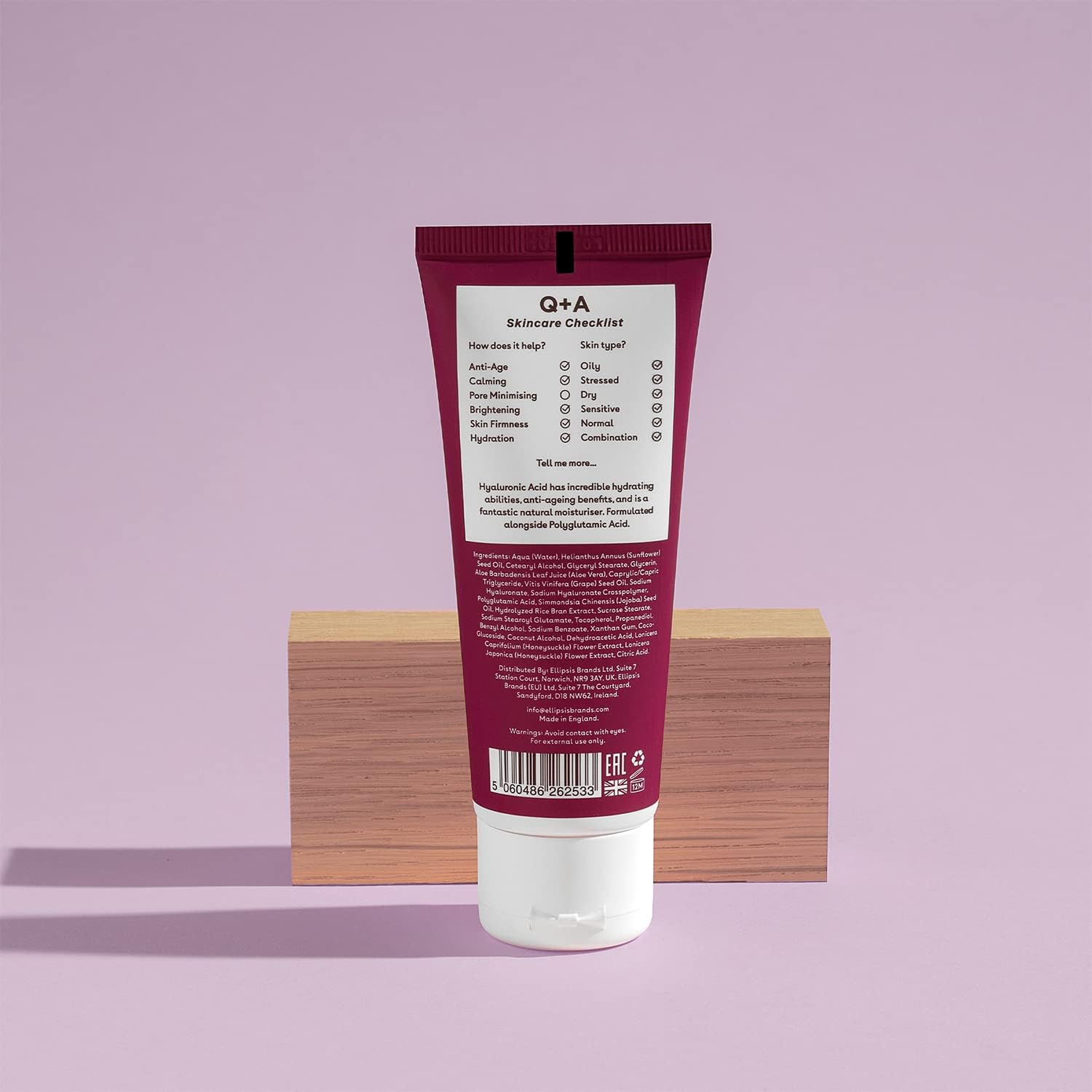Tube of Q+A product with visible label on a wooden block against a purple background