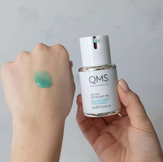 QMS Medicosmetics Active Exfoliant 7% Resurfacing Fluid in hand, showcasing smooth gel texture for glowing skin.
