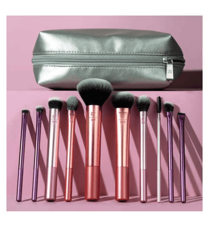 Set of Real Techniques makeup brushes with a silver case on a pink background