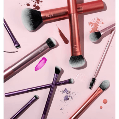 Real Techniques Makeup brushes with pink and purple handles on a pink background