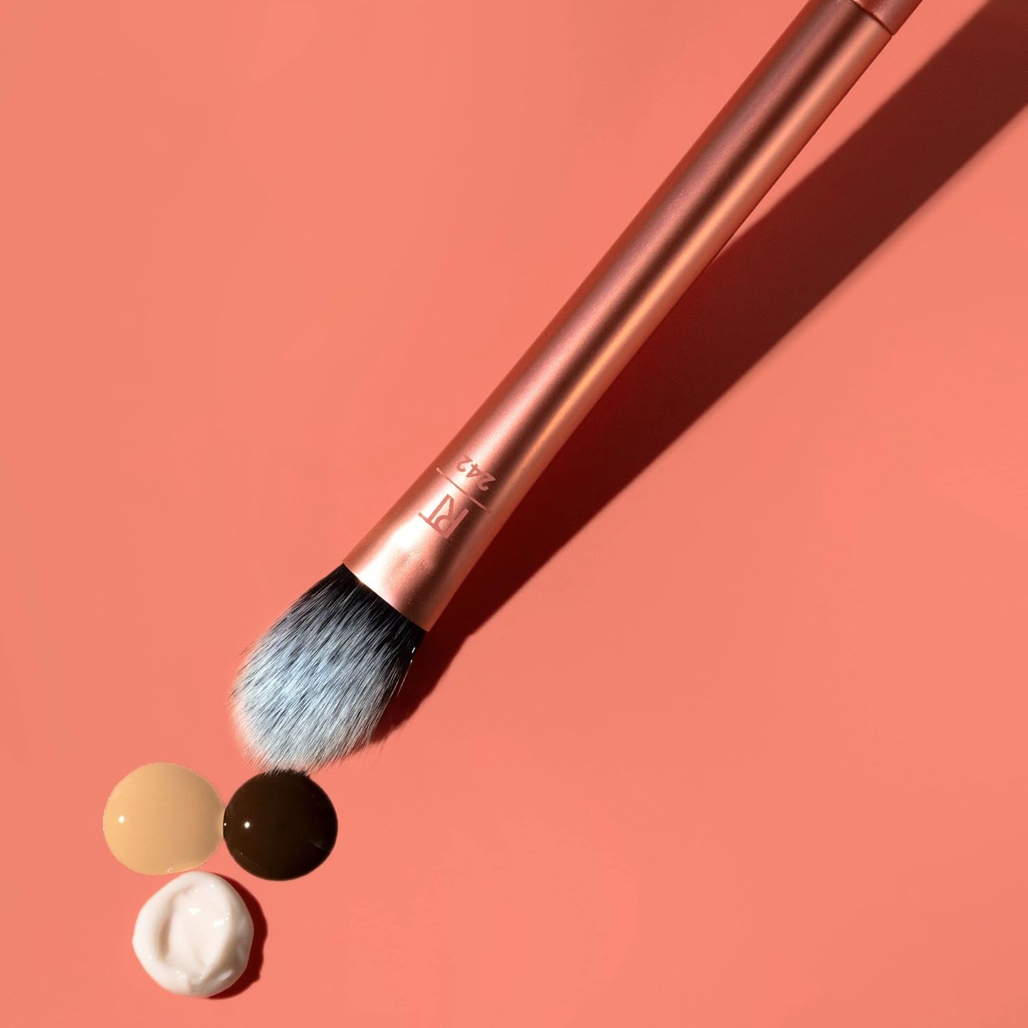 Makeup brush with black bristles on a pink background