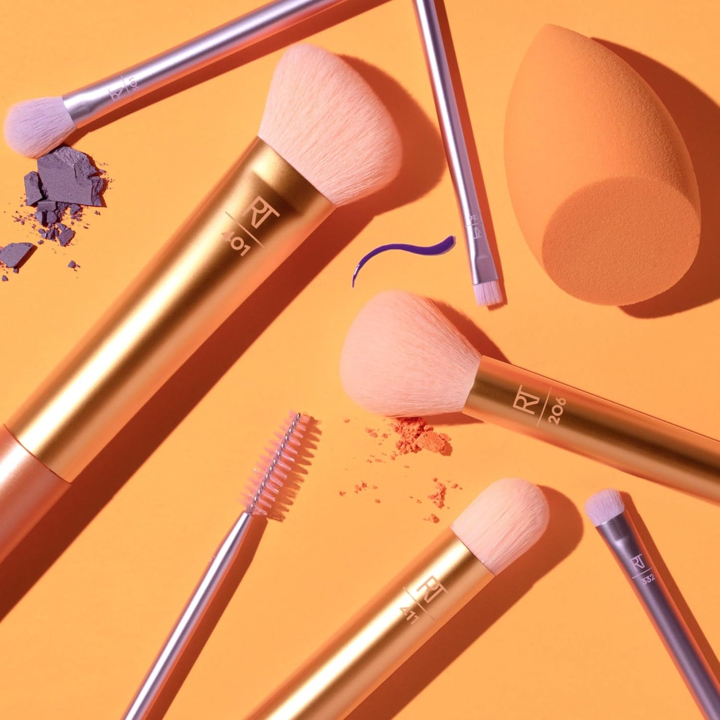 Makeup brushes and a sponge on an orange background