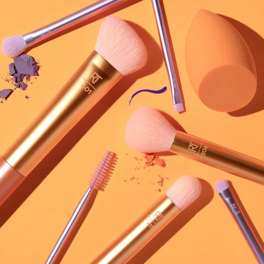 Makeup brushes and a sponge on an orange background