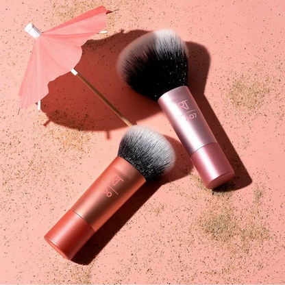 Two makeup brushes with pink and red handles on a pink textured background