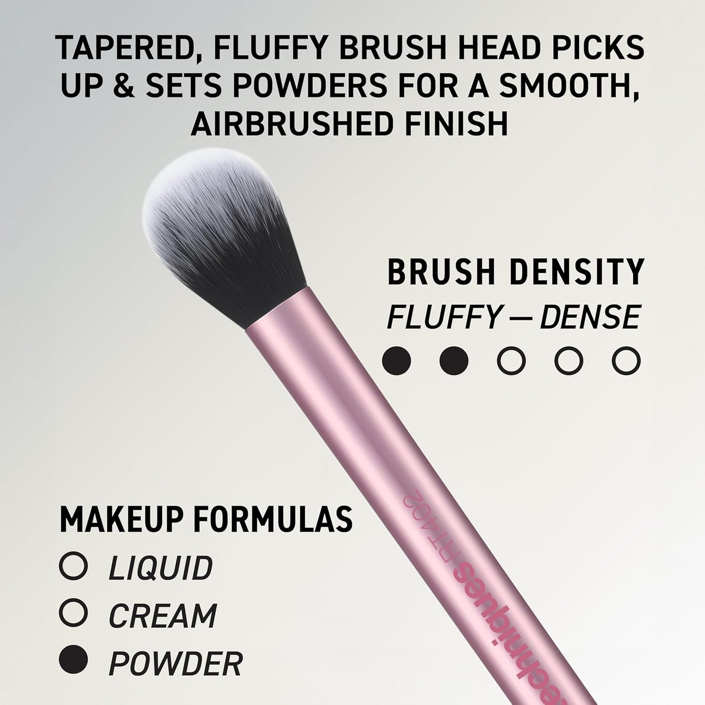 Real Techniques Makeup brush with pink handle and fluffy bristles on a gray background, featuring text about brush density and use.