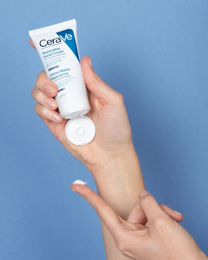 CeraVe hand cream being applied to a hand against a blue background