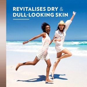 Two women joyfully running on the beach, promoting revitalizing skin care for dry and dull-looking skin.
