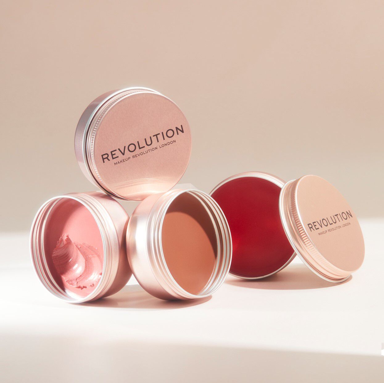 Revolution Lip & Cheek Balm Glow in elegant packaging showcasing multiple shades for lips and cheeks.