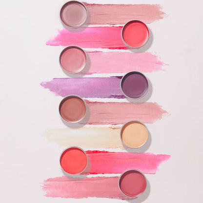 Set of  Revolutionlip glosses with swatches on a light pink background