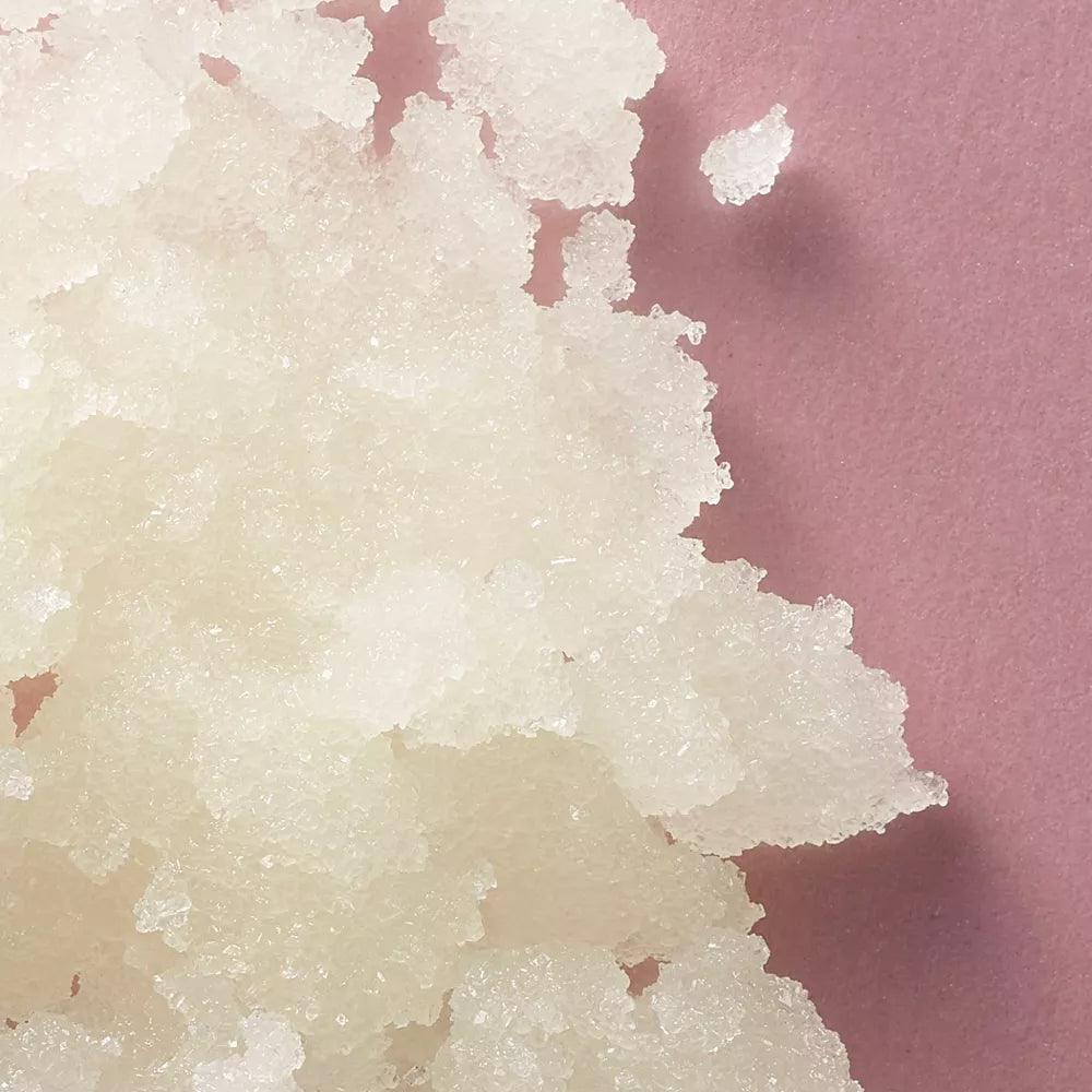 Close-up of white sugar crystals for body polish, enhancing skin exfoliation and rejuvenation.