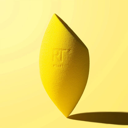 Yellow beauty blender with 'RT' logo on a yellow background