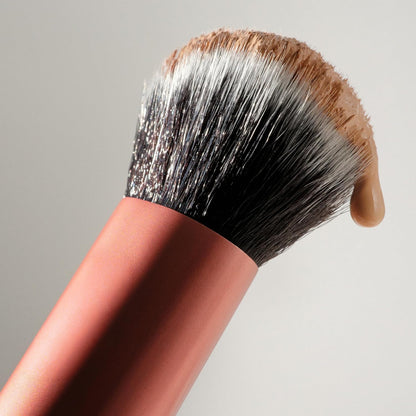 Makeup brush with a wooden handle and synthetic hair on a neutral background