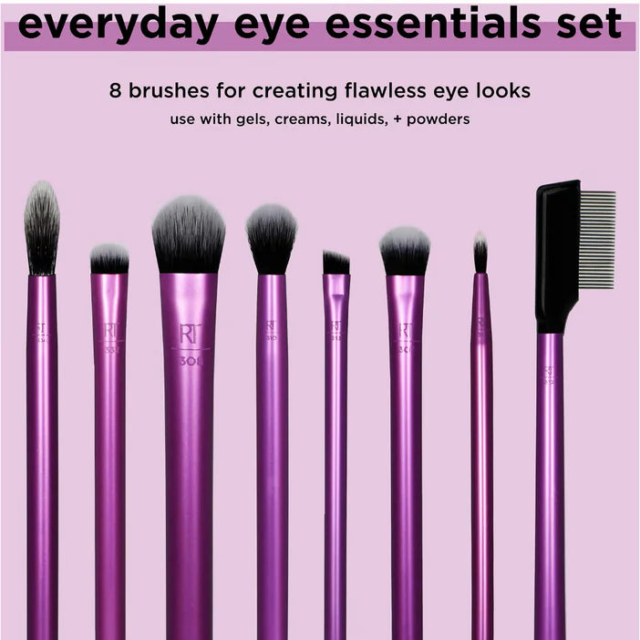 Set of makeup brushes with pink handles on a pink background, labeled 'everyday eye essentials set'.