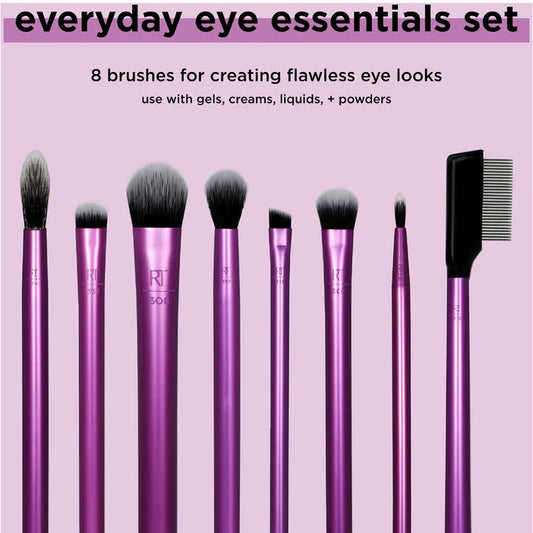 Set of makeup brushes with pink handles on a pink background, labeled 'everyday eye essentials set'.