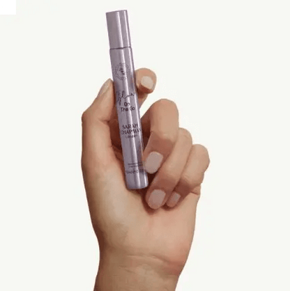 Hand holding Sarah Chapman Glow On The Go Illuminating Elixir, 10ml for a radiant boost anytime.