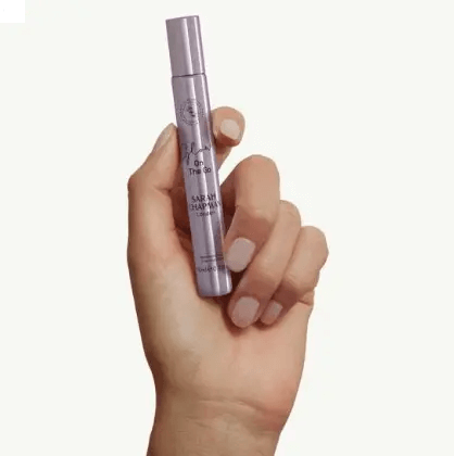 Hand holding Sarah Chapman Glow On The Go Illuminating Elixir, 10ml for a radiant boost anytime.