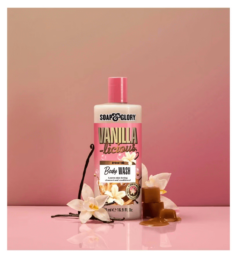 Soap & Glory Vanilla-licious Body Wash bottle surrounded by vanilla flowers and caramel, promoting a luxurious bath experience.