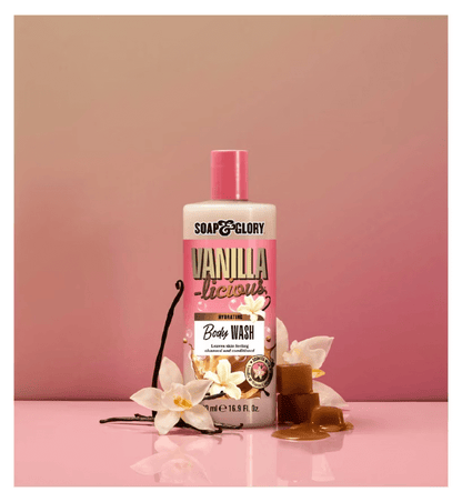 Soap & Glory Vanilla-licious Body Wash bottle surrounded by vanilla flowers and caramel, promoting a luxurious bath experience.
