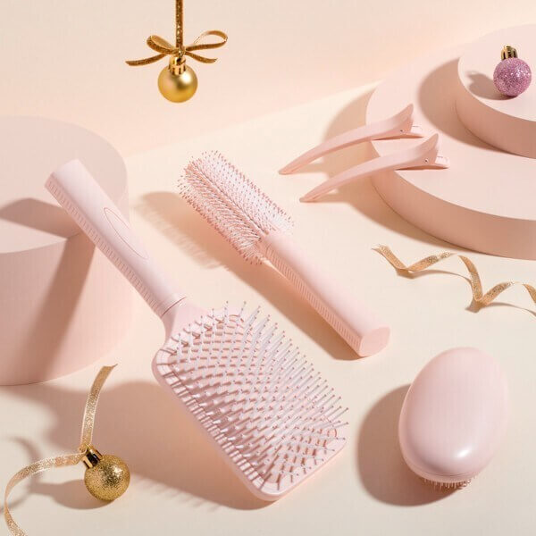Studio London 5 piece Hair Styling Collection including brushes and clips on a soft pink background.