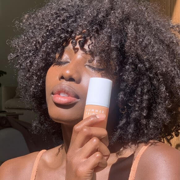 Model showcasing Summer Fridays CC Me Serum in natural light for radiant skin.