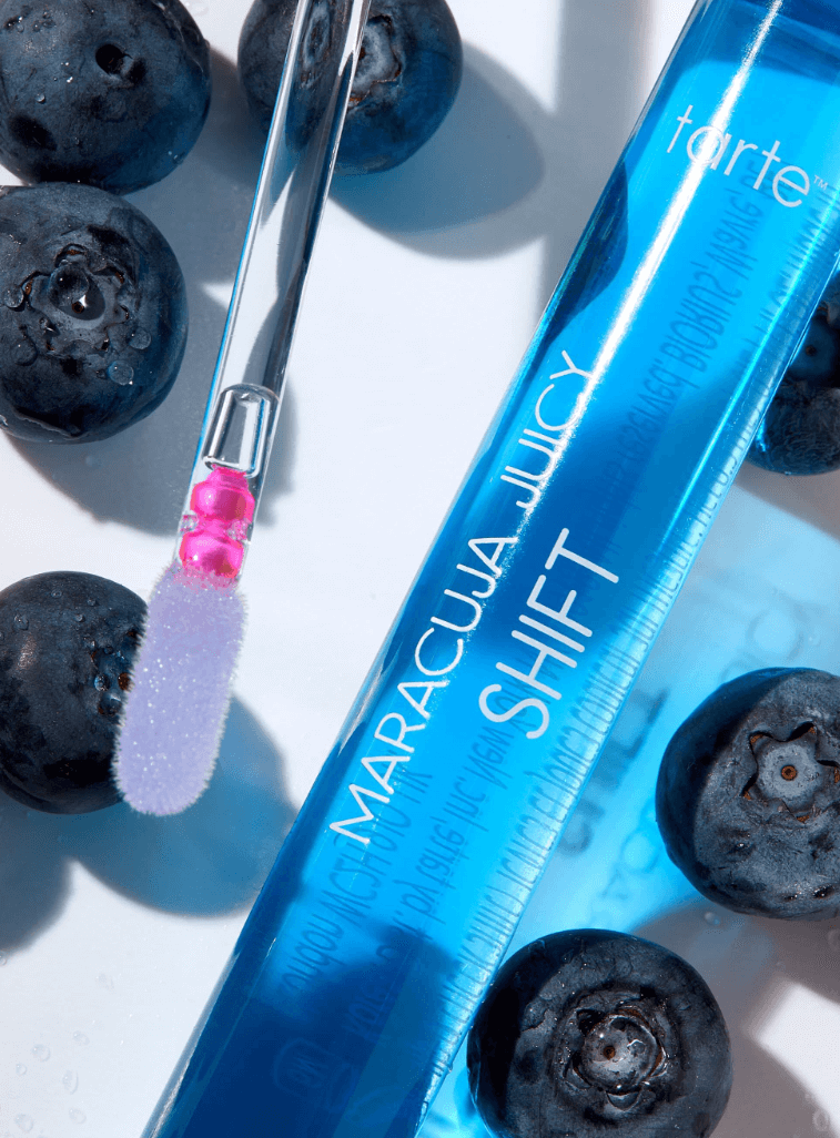 Tarte Maracuja Juicy Lip & Cheek Shift in Blueberry with applicator and blueberries, showcasing vibrant color transformation.