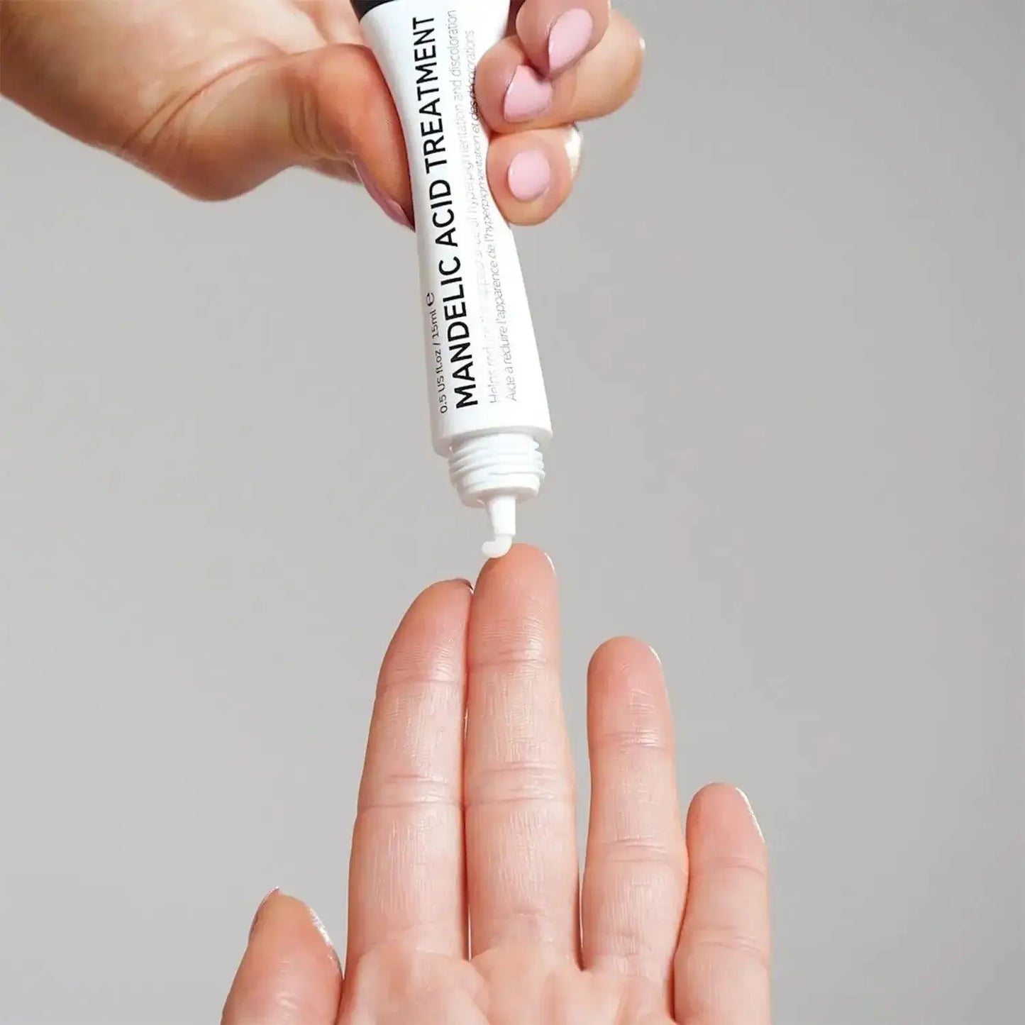 Person applying The INKEY List Mandelic Acid Treatment from the tube onto their hand, highlighting clear skin benefits.