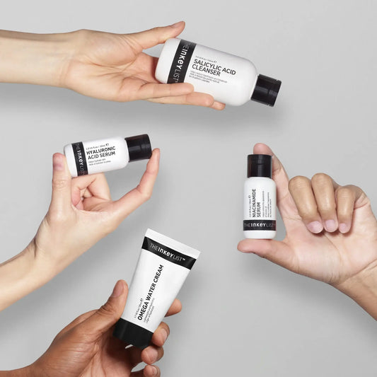 Hands holding The INKEY List Oily Skin Solution Bundle including cleanser, serum, and moisturizer for oily skin.