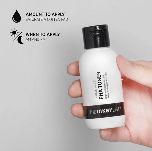 Person holding The INKEY List PHA Toner bottle, instructions for use and application amount displayed.