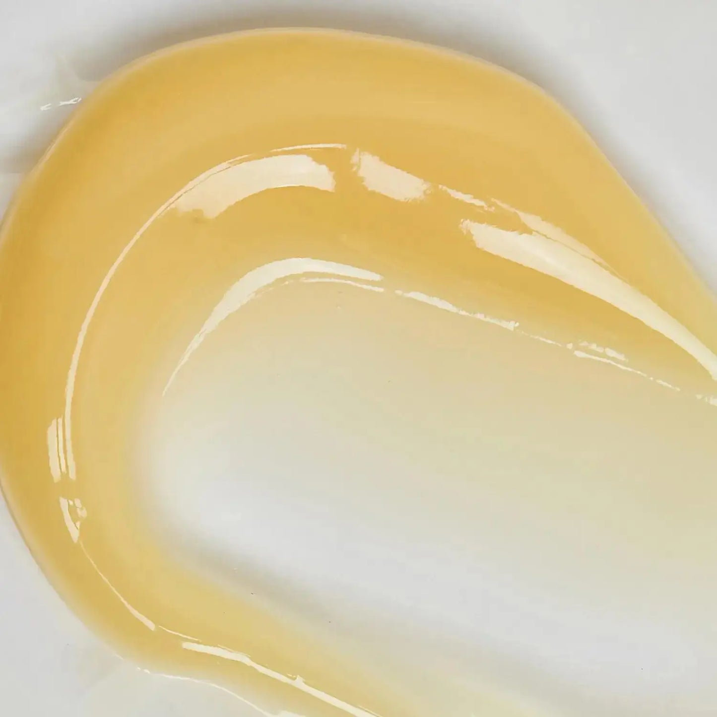 Close-up of The INKEY List Retinol Serum texture showing a smooth, golden gel consistency on white background.