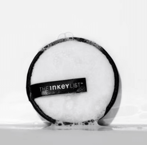 THE INKEY LIST Reusable Cleansing Pad with bubbles on a surface, showcasing its dual-textured eco-friendly design.