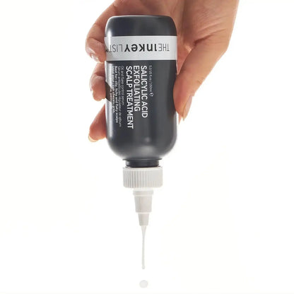 The INKEY List Salicylic Acid Exfoliating Scalp Treatment bottle in hand, ready to apply for healthy hair.