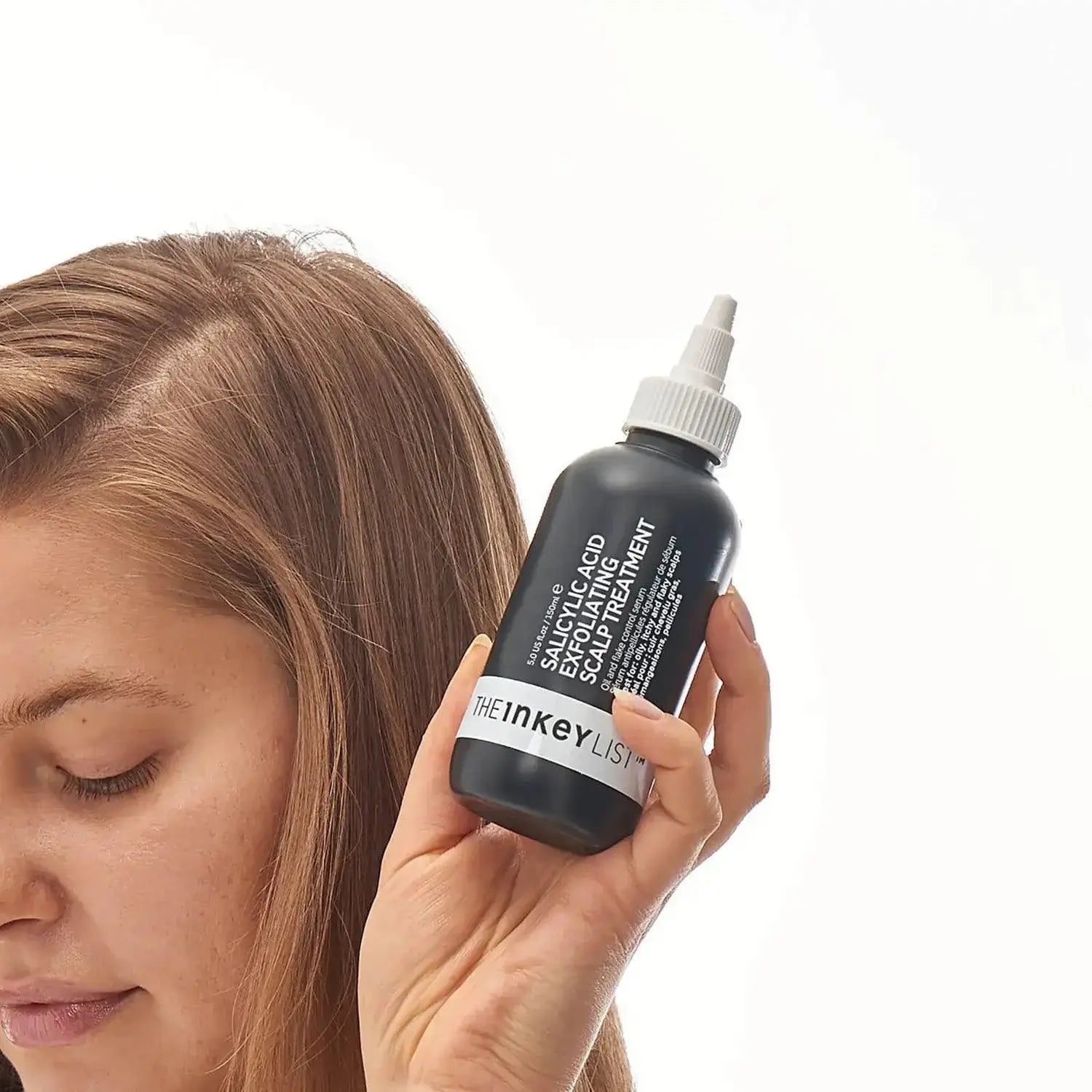 The INKEY List Salicylic Acid Exfoliating Scalp Treatment in hand, promoting healthy hair growth and scalp care.