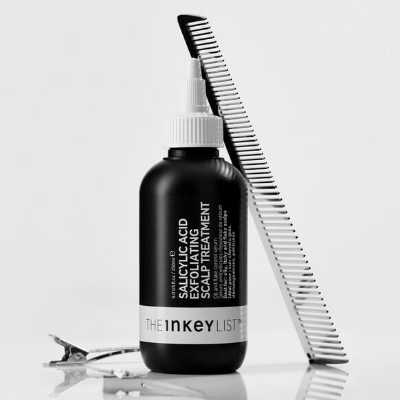 The INKEY List Salicylic Acid Exfoliating Scalp Treatment bottle with a comb, promoting healthy hair growth.