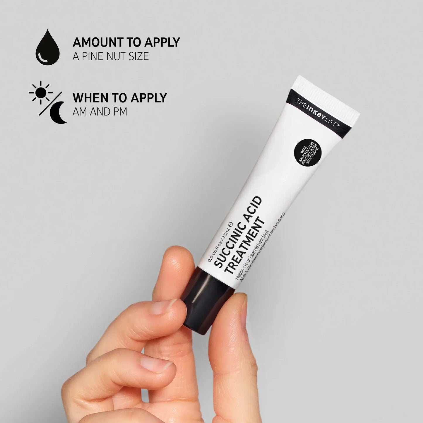 Hand holding The Inkey List Succinic Acid Treatment tube with application tips for blemish-prone skin.