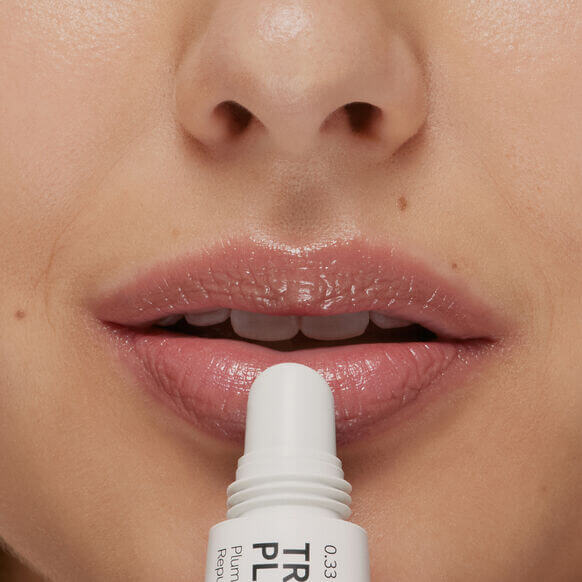 Close-up of lips applying The INKEY List Tripeptide Plumping Lip Balm 10ml for hydration and volume.