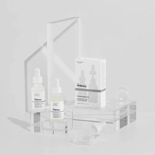 The Ordinary The Skin Support Set displayed with two serums and packaging on a clear surface, showcasing hydrating skincare.