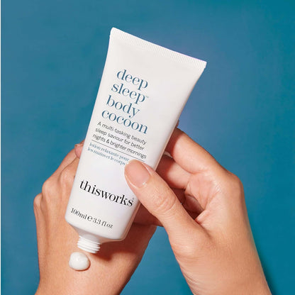 Hand holding thisworks 'deep sleep body cocoon' product with a blue background