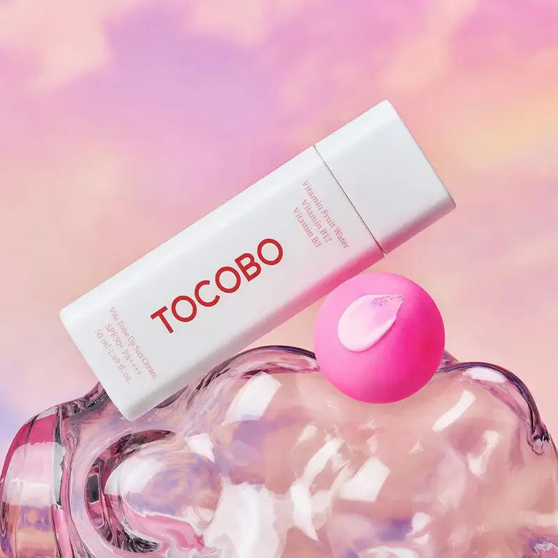 TOCOBO Vita Tone Up Sun Cream SPF50+ PA++++ 50ml on a colorful background with a pink applicator.