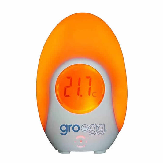 Tommee Tippee Groegg Digital Thermometer displaying 21.7°C with a soft orange glow, indicating optimal room temperature for baby.