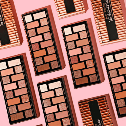 Too Faced Makeup palettes with a variety of colors on a pink background