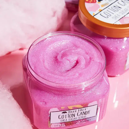Jar of Tree Hut Cotton Candy Shea Sugar Scrub with a pink swirl texture, surrounded by cotton candy-themed elements.