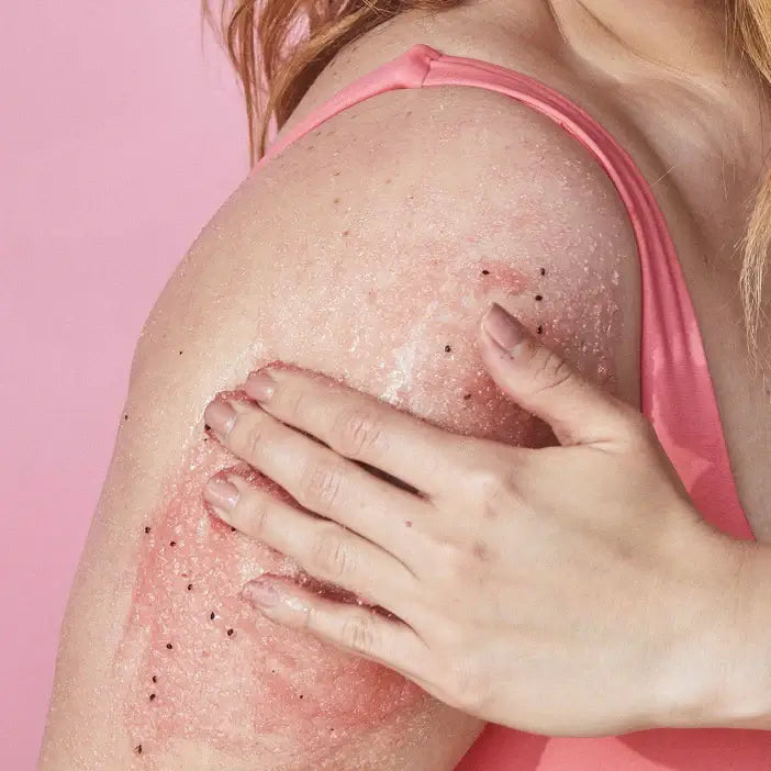 Person using TREE HUT Watermelon Sugar Scrub on their shoulder against a pink background