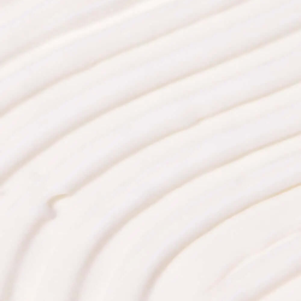 Close-up of creamy, TREE HUT Coco Colada Whipped Body Butter whipped body butter texture with soft, smooth swirls.