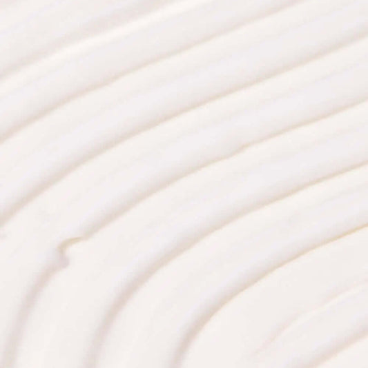 Close-up of creamy, TREE HUT Coco Colada Whipped Body Butter whipped body butter texture with soft, smooth swirls.