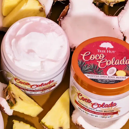 Two containers of Tree Hut Coco Colada whipped shea body butter with pineapple slices around them.