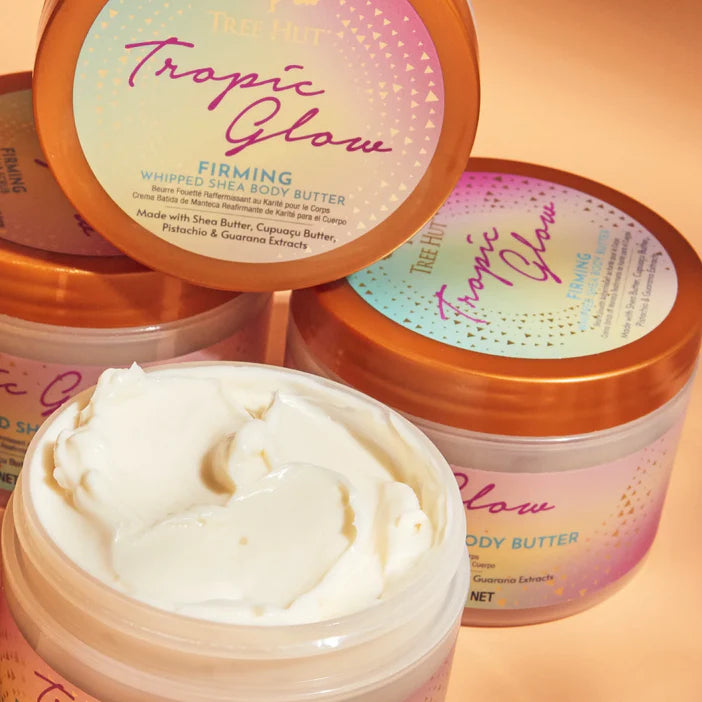 Tree Hut Tropic Glow whipped shea body butter with visible cream on a peach background