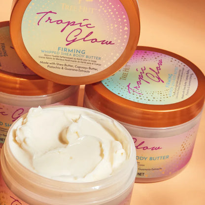 Tree Hut Tropic Glow whipped shea body butter with visible cream on a peach background