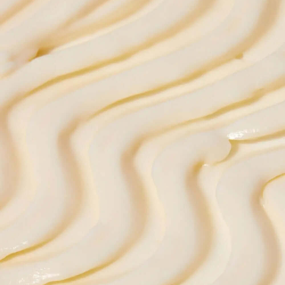Close-up of creamy, Tree Hut Whipped Body Butter Tropic Glow whipped body butter with smooth, textured swirls, perfect for hydration and nourishment.