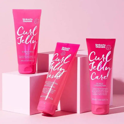 Three pink bottles of Umberto Giannini Curl Jelly on a pink background