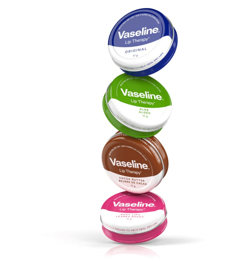 Stack of Vaseline Lip Therapy tins including Original, Aloe, Cocoa Butter, and Rosy Lips flavors.